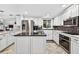 Kitchen featuring white cabinets, stainless steel appliances, and a large island perfect for cooking at 3620 Little Rd, Lutz, FL 33548