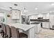 Modern kitchen with white cabinetry, a stainless steel refrigerator, and a stylish island with a dark countertop at 3620 Little Rd, Lutz, FL 33548