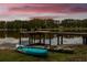 Lake view featuring a dock and kayaks, perfect for water recreation at 3620 Little Rd, Lutz, FL 33548