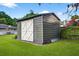Durable storage shed with double doors, blending seamlessly into the landscaped yard at 3620 Little Rd, Lutz, FL 33548