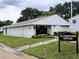 Exterior of well-kept community clubhouse building with green lawn, landscaping, and signage at 3810 N Oak Dr # N31, Tampa, FL 33611