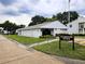 Exterior of well-kept community clubhouse building with green lawn, landscaping, and signage at 3810 N Oak Dr # N31, Tampa, FL 33611
