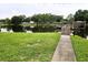 Scenic view of lake with dock, grassy shoreline, lush trees, and serene water, perfect for relaxation at 3810 N Oak Dr # N31, Tampa, FL 33611