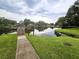Scenic view of lake with dock, grassy shoreline, lush trees, and serene water, perfect for relaxation at 3810 N Oak Dr # N31, Tampa, FL 33611