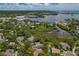 Aerial view of a waterfront community with mature trees and manicured lawns at 389 Grand Bay Dr, Palm Harbor, FL 34683
