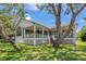 Charming white home exterior with a covered back porch offers a delightful outdoor living space at 389 Grand Bay Dr, Palm Harbor, FL 34683