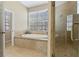 Bathroom featuring a garden tub with tile surround and a separate glass door walk-in shower at 389 Grand Bay Dr, Palm Harbor, FL 34683