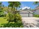Spacious three-car garage and landscaped front yard enhance the curb appeal of this inviting home at 389 Grand Bay Dr, Palm Harbor, FL 34683