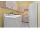 Bright laundry room with white cabinets, appliances, and tile floor at 389 Grand Bay Dr, Palm Harbor, FL 34683
