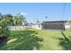 A spacious, green backyard featuring grass and a screened-in patio area at 4015 Overlook Ne Dr, St Petersburg, FL 33703