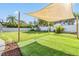 Expansive backyard featuring lush artificial turf, shade sail, and mature landscaping, great for entertaining at 4015 Overlook Ne Dr, St Petersburg, FL 33703