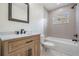 Modern bathroom with gray-tiled shower, black fixtures, and wood vanity with white marble countertop at 4015 Overlook Ne Dr, St Petersburg, FL 33703