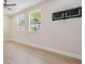 Bright bedroom with wood floors, neutral walls, and two windows at 4015 Overlook Ne Dr, St Petersburg, FL 33703