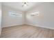 Neutral bedroom features light walls, trim and flooring, a ceiling fan and two windows at 4015 Overlook Ne Dr, St Petersburg, FL 33703
