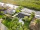 Aerial view of a single-Gathering home with lush landscaping, a large driveway, and waterfront access with a private dock at 4157 Marine Pkwy, New Port Richey, FL 34652