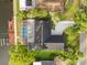 Aerial view of a waterfront home with a screened-in pool, a private dock, and lush landscaping in a residential neighborhood at 4157 Marine Pkwy, New Port Richey, FL 34652