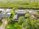 Aerial view of a single-Gathering home with lush landscaping, a large driveway, and waterfront access with a private dock at 4157 Marine Pkwy, New Port Richey, FL 34652
