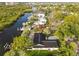Aerial view of a waterfront home with a screened-in pool, a private dock, and lush landscaping in a residential neighborhood at 4157 Marine Pkwy, New Port Richey, FL 34652