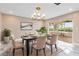 Elegant dining area with modern chandelier, a slider to the lanai, and neutral color scheme at 4157 Marine Pkwy, New Port Richey, FL 34652