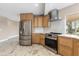 Well-appointed kitchen with stainless steel refrigerator, oven, and light wood cabinetry at 4157 Marine Pkwy, New Port Richey, FL 34652