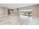 Bright open-plan living room with large sliding doors, tiled floors, and a glimpse of the pool area at 4157 Marine Pkwy, New Port Richey, FL 34652