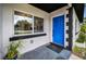 Inviting entryway featuring a bright blue front door, modern tile flooring, and lush greenery at 4441 16Th N St, St Petersburg, FL 33703