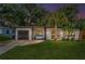 Dusk view of a modern one story home with black trim, a front lawn and mature landscaping at 4441 16Th N St, St Petersburg, FL 33703