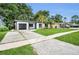 Charming single-story home featuring a modern exterior, landscaped yard, and a driveway leading to an attached garage at 4441 16Th N St, St Petersburg, FL 33703