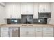 Modern kitchen with white cabinets, granite countertops, and a black tile backsplash at 4441 16Th N St, St Petersburg, FL 33703