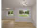 Bright living room with updated modern light fixture, light wood flooring and a view out of two large windows at 4441 16Th N St, St Petersburg, FL 33703