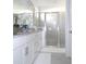 Bathroom featuring white cabinets, granite countertops, framed mirrors, and a glass shower at 4957 Seafoam Trl, Bradenton, FL 34211