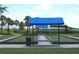 Bocce ball court with blue awnings, seating, and lush tropical landscaping at 4957 Seafoam Trl, Bradenton, FL 34211