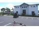 Community clubhouse featuring lush landscaping, palm trees, and a golf cart in the parking lot at 4957 Seafoam Trl, Bradenton, FL 34211