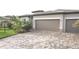 Beautiful single-story home featuring a well-maintained lawn, manicured landscaping, and a two-car garage with a paver driveway at 4957 Seafoam Trl, Bradenton, FL 34211