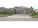 Beautiful single-story home featuring a well-maintained lawn, tropical landscaping, and a three-car garage with a paver driveway at 4957 Seafoam Trl, Bradenton, FL 34211