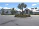 Beautiful community clubhouse with lush landscaping, palm trees, and a circular driveway at 4957 Seafoam Trl, Bradenton, FL 34211