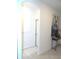 Bright hallway featuring neutral tile flooring, white walls, arched doorway and elegant decor at 4957 Seafoam Trl, Bradenton, FL 34211