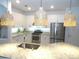 Bright kitchen features a granite island with sink, modern appliances, white cabinets, and pendant lighting at 4957 Seafoam Trl, Bradenton, FL 34211