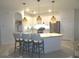 Bright kitchen features a granite island with pendant lighting, modern appliances and white cabinetry at 4957 Seafoam Trl, Bradenton, FL 34211