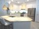 Modern eat-in kitchen featuring stainless steel appliances, granite countertops, white cabinetry and a center island with seating at 4957 Seafoam Trl, Bradenton, FL 34211