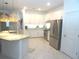 Modern eat-in kitchen featuring stainless steel appliances, granite countertops, white cabinetry and a center island with seating at 4957 Seafoam Trl, Bradenton, FL 34211