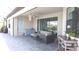 A covered patio has seating, a ceiling fan, a built-in bar, and large sliding glass doors at 4957 Seafoam Trl, Bradenton, FL 34211