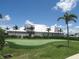 Putting green nestled near a white home and lush, tropical landscaping at 4957 Seafoam Trl, Bradenton, FL 34211