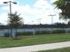 Well-maintained tennis courts with a fence and manicured landscaping in the background at 4957 Seafoam Trl, Bradenton, FL 34211