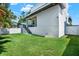 Expansive backyard featuring lush green grass and a modern home exterior with a covered porch at 5006 W Idaho St, Tampa, FL 33616