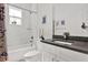 Modern bathroom with marble tile, bathtub, shower combo, and sleek vanity with gray countertop at 5006 W Idaho St, Tampa, FL 33616