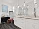 Bright bathroom featuring large vanity, dual sinks, elegant light fixtures, and glass shower at 5006 W Idaho St, Tampa, FL 33616