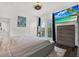 Bedroom featuring large TV, ceiling fan, decor, and access to balcony via french doors with black accents at 5006 W Idaho St, Tampa, FL 33616