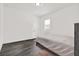 Simple bedroom with gray floors and white walls, including a single bed, and single window at 5006 W Idaho St, Tampa, FL 33616