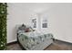Bedroom with floral pattern bedding, gray floors, light walls, and a pair of windows at 5006 W Idaho St, Tampa, FL 33616